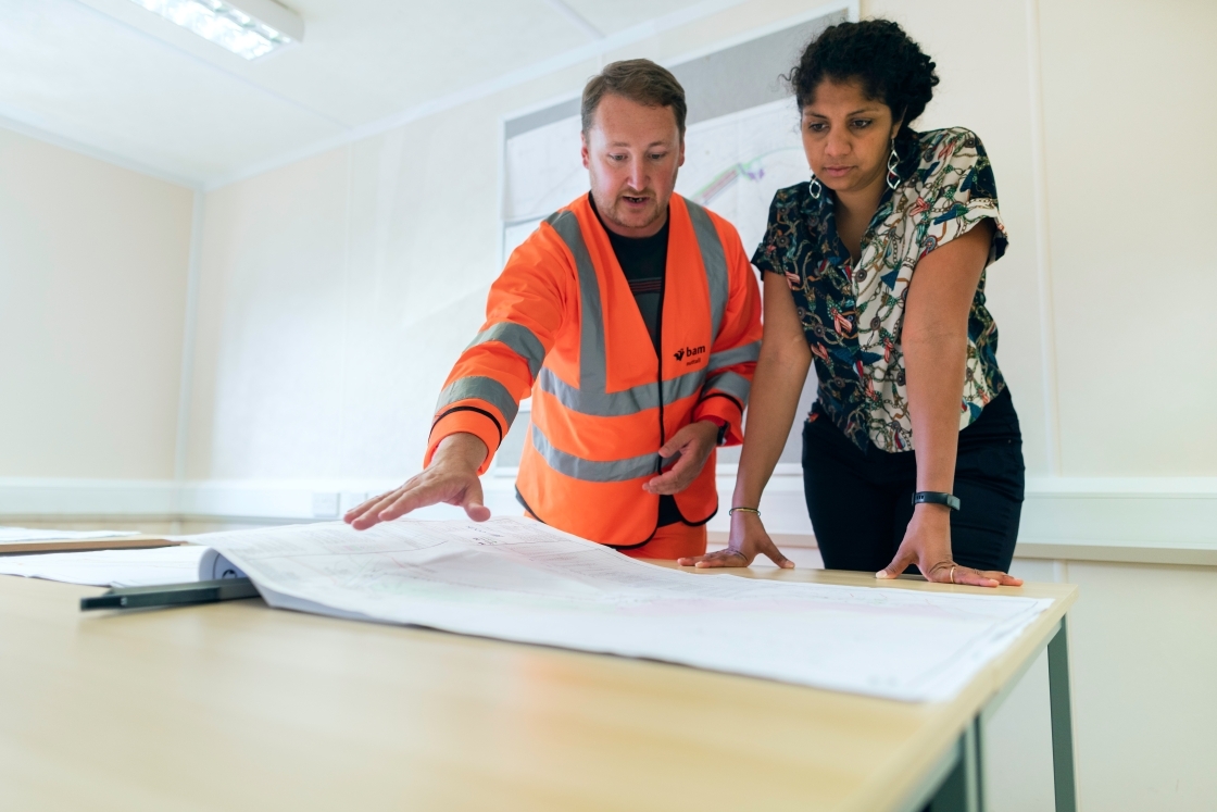 Two people looking over blueprints